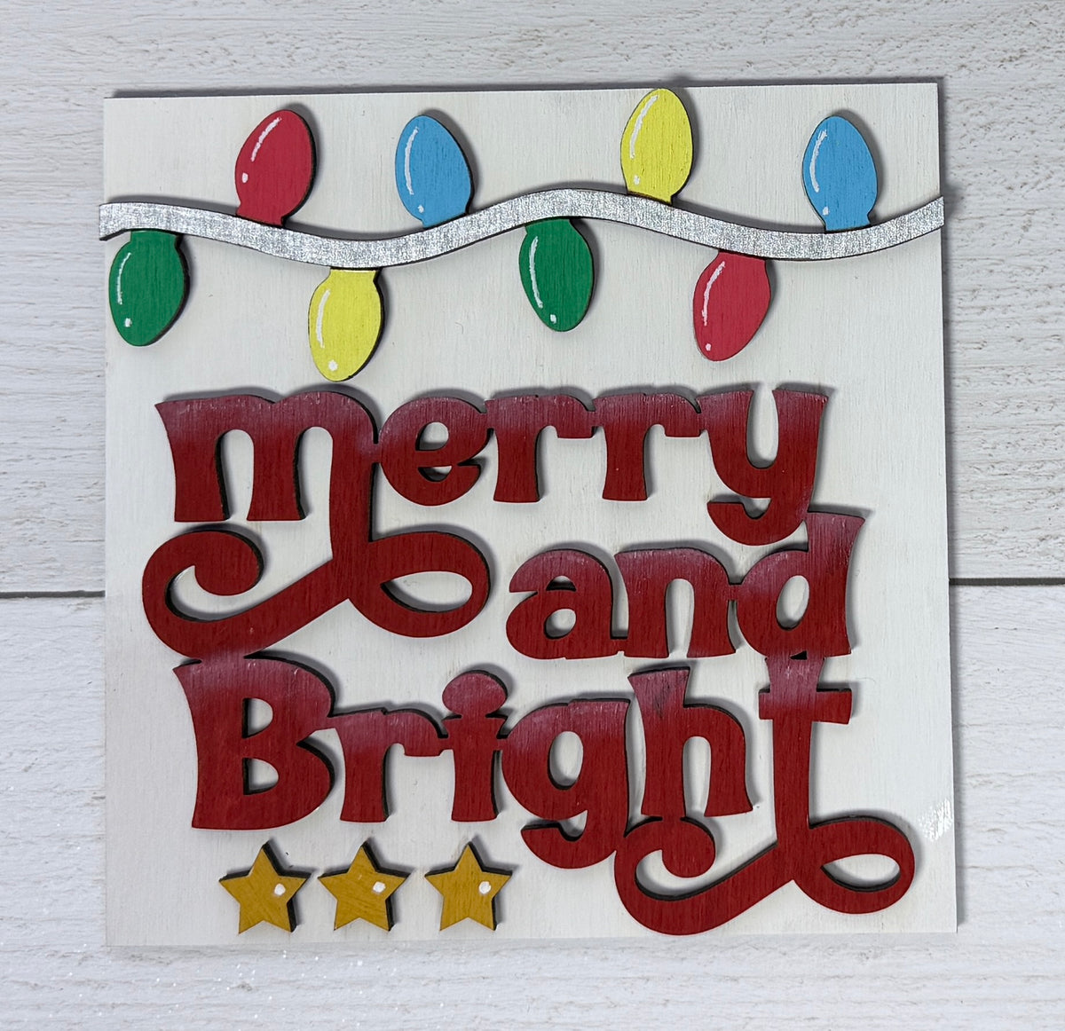 a sign with a string of lights and stars on a white surface