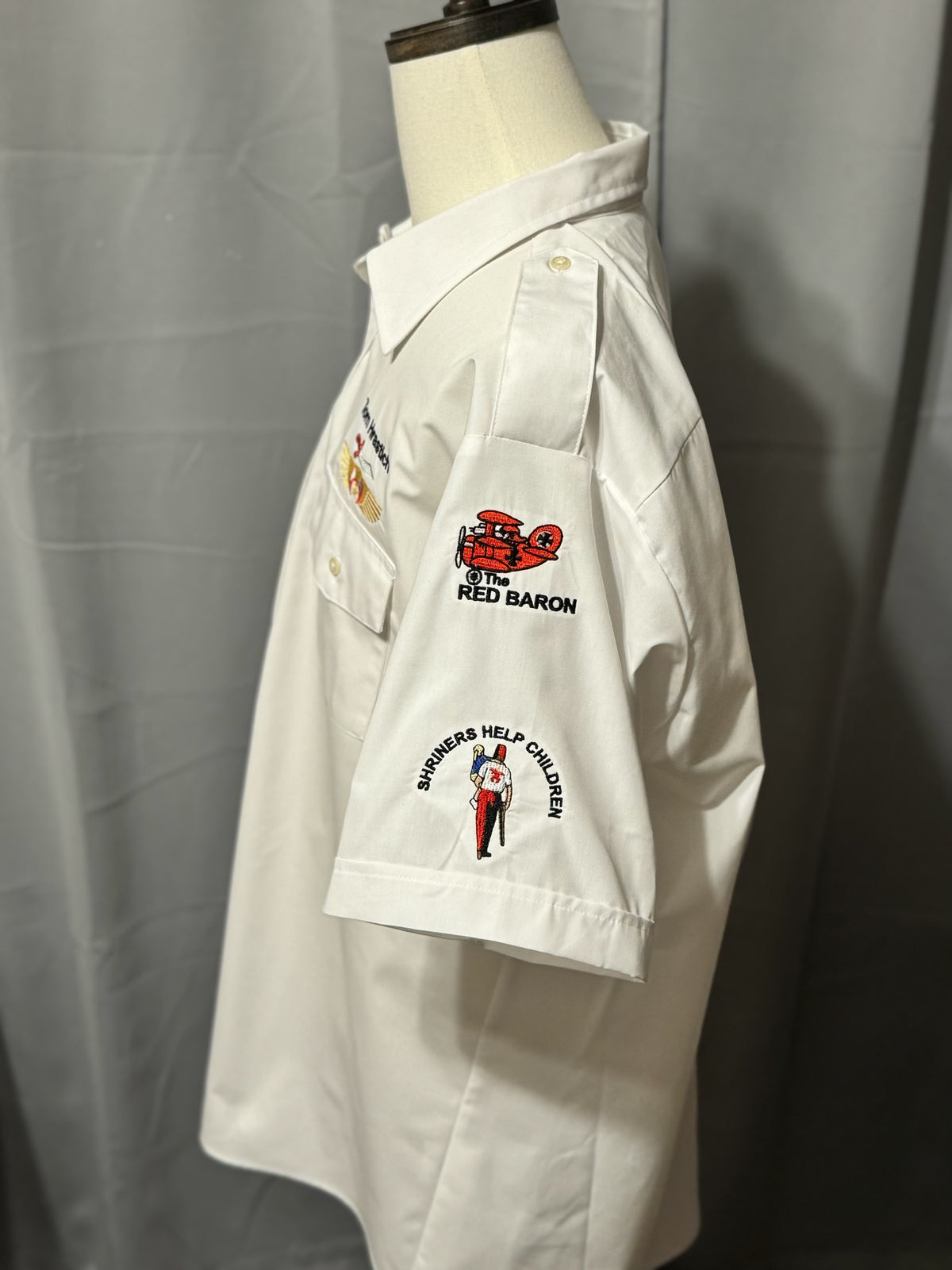 a white shirt with embroidered patches on it
