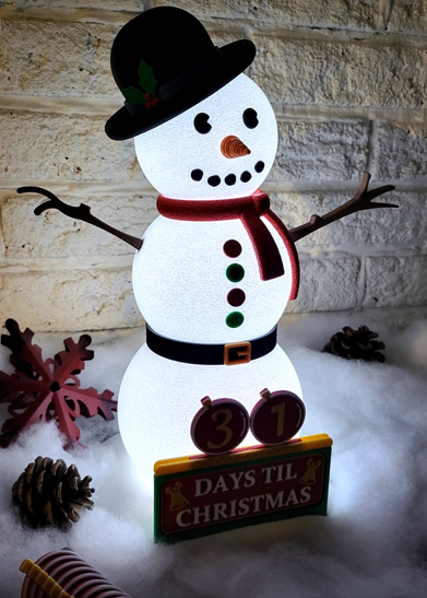 Snowman with a countdown to Christmas display against a stone wall.