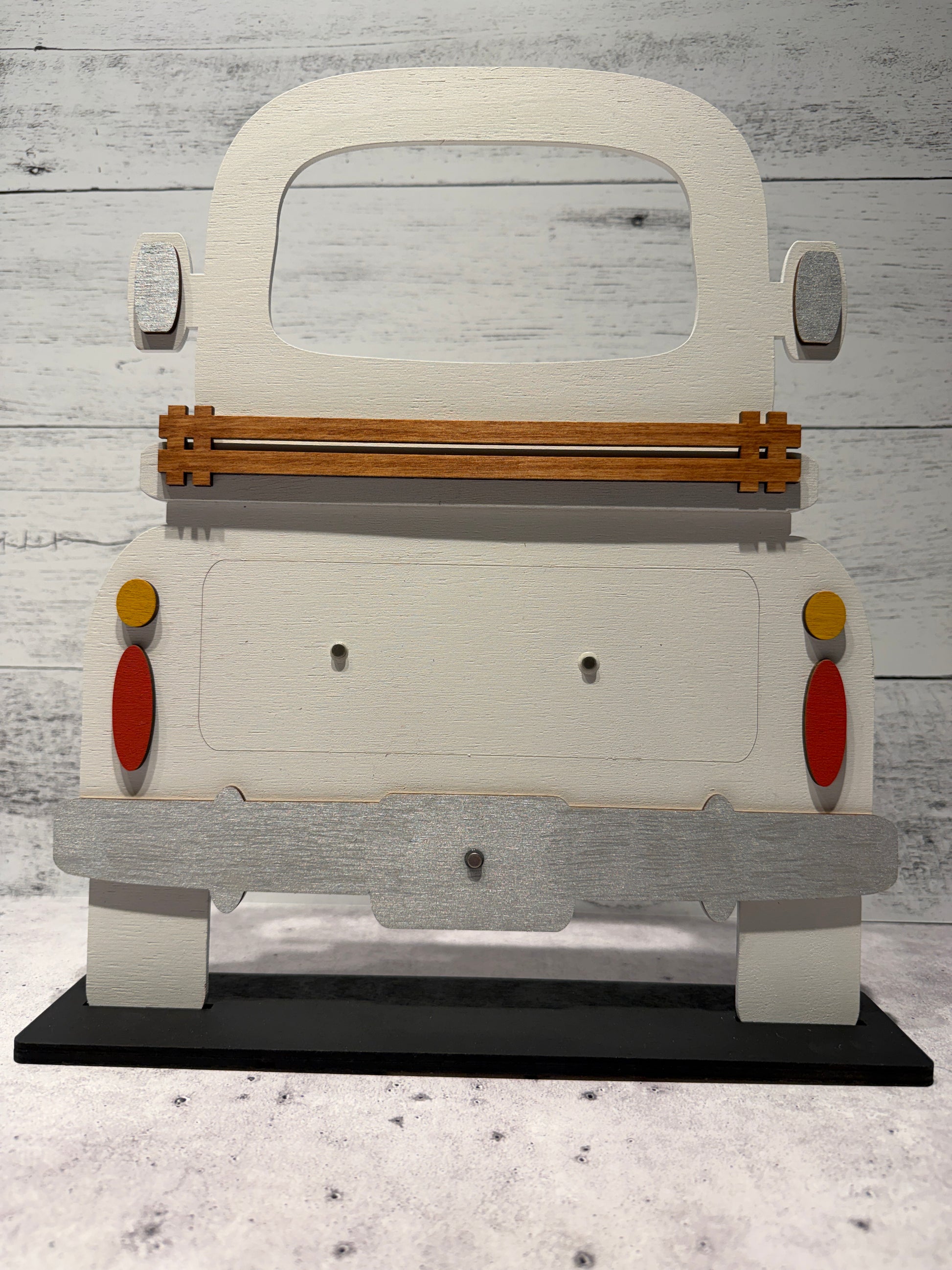 Wooden toy car with colorful wheels on a textured gray surface