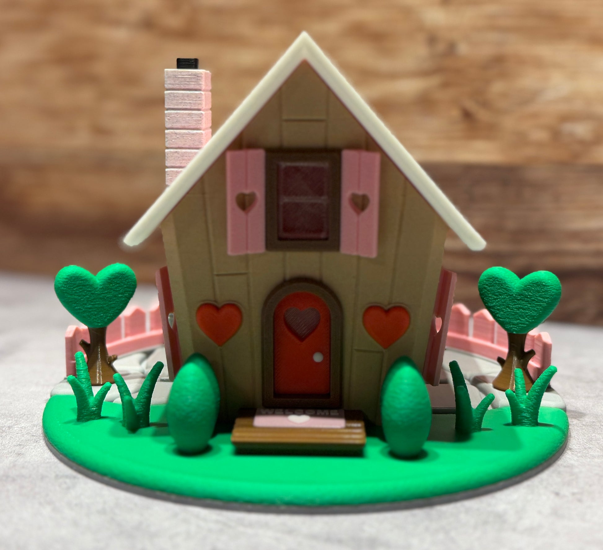 Toy house with heart-shaped details on a green base