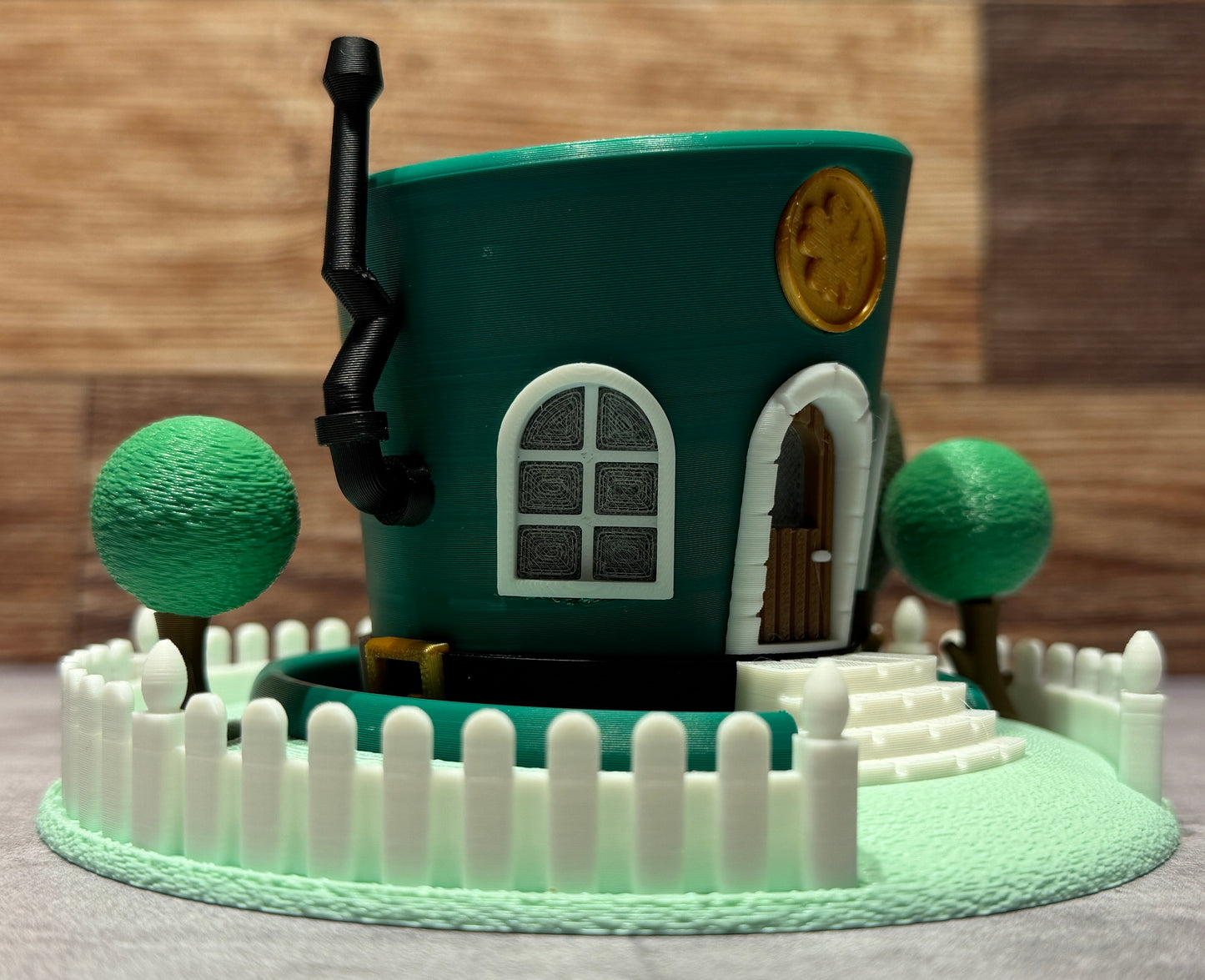 Toy house surrounded by trees and a fence