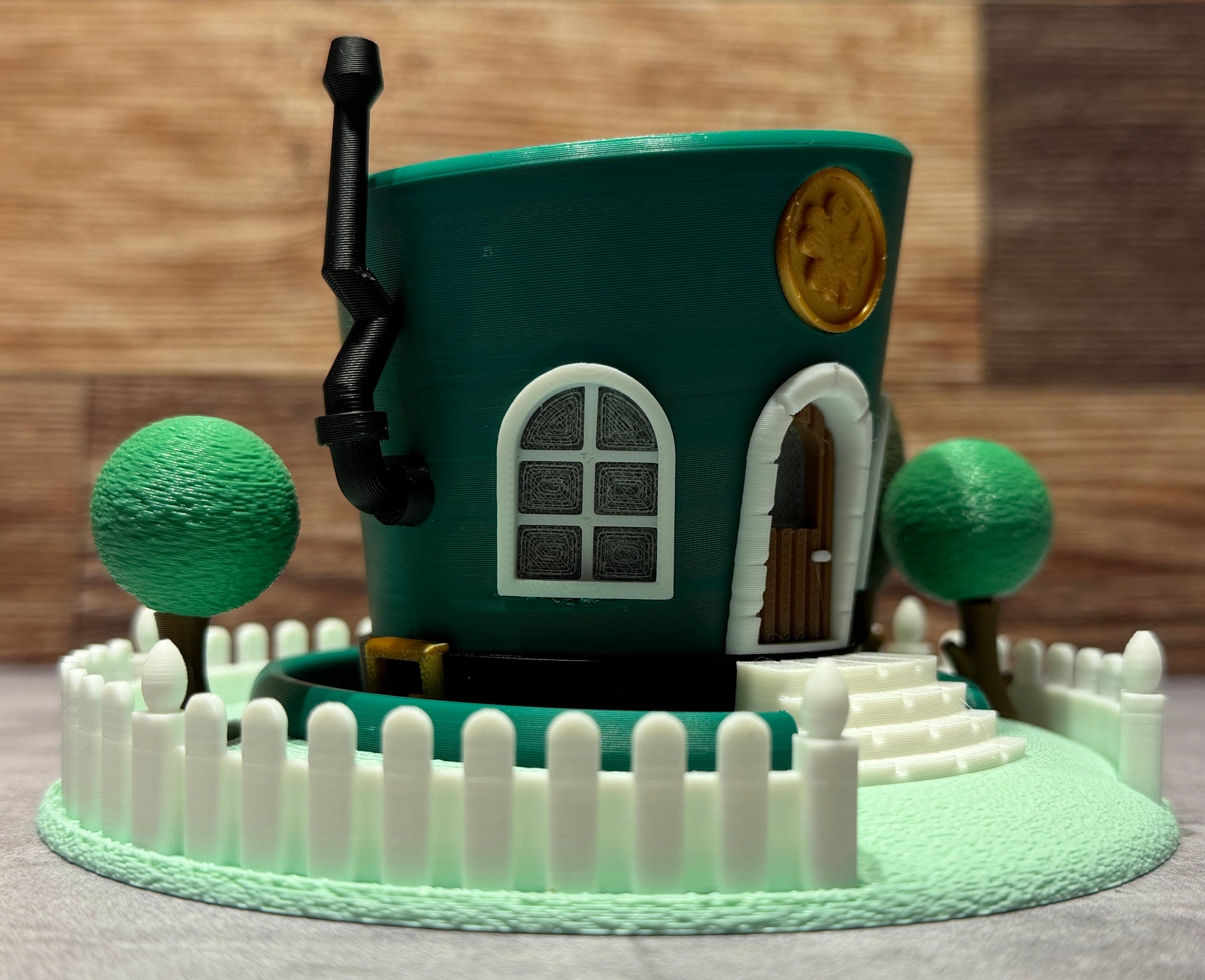 Toy house surrounded by trees and a fence