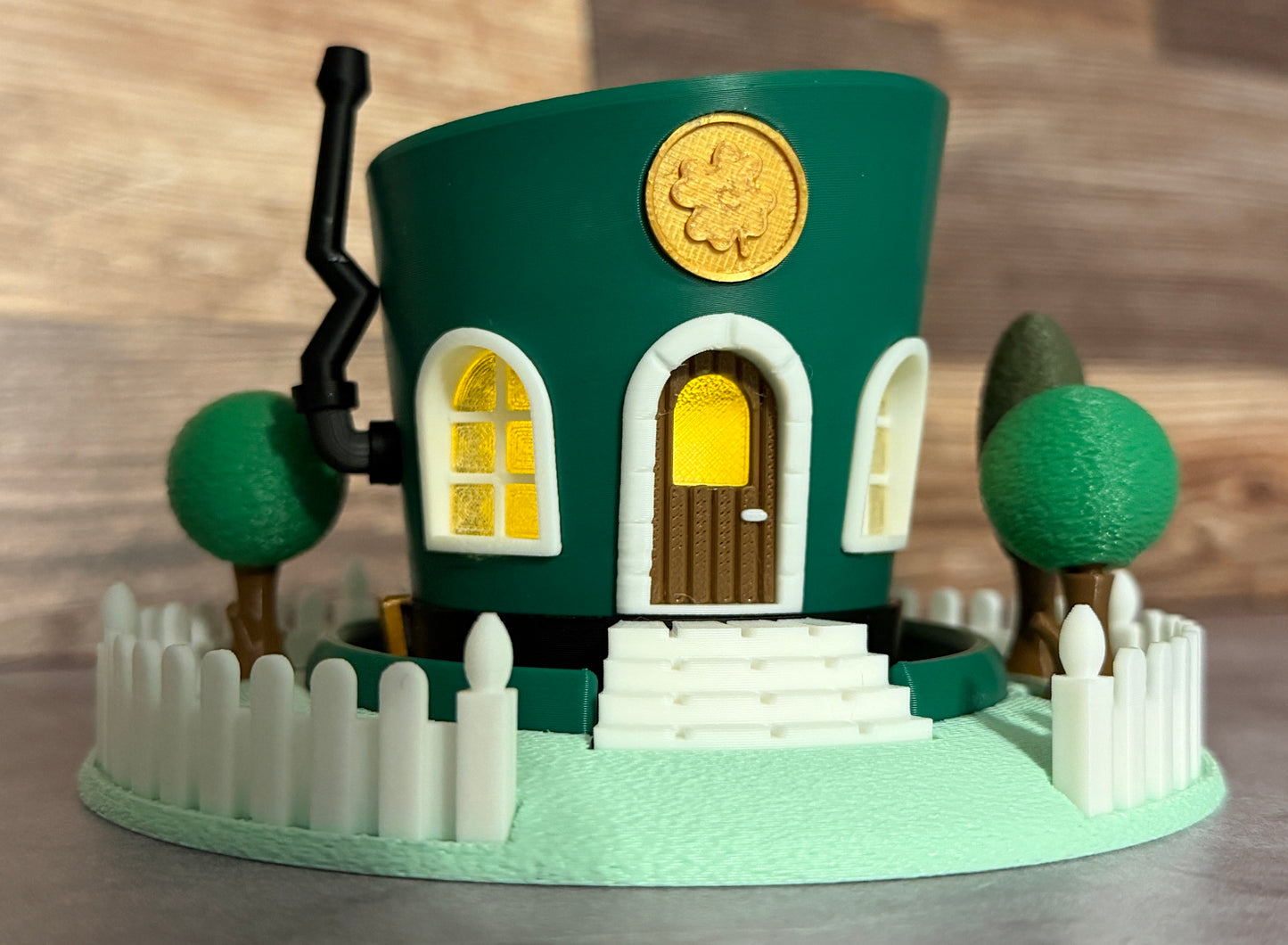Model of a green house with a yellow door and windows