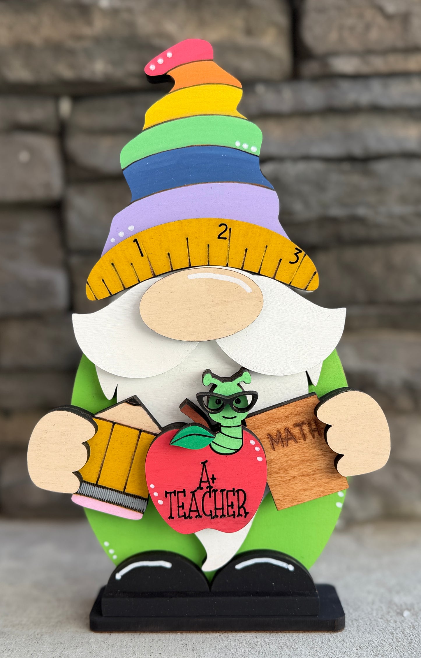 a wooden toy gnome with a ruler on it