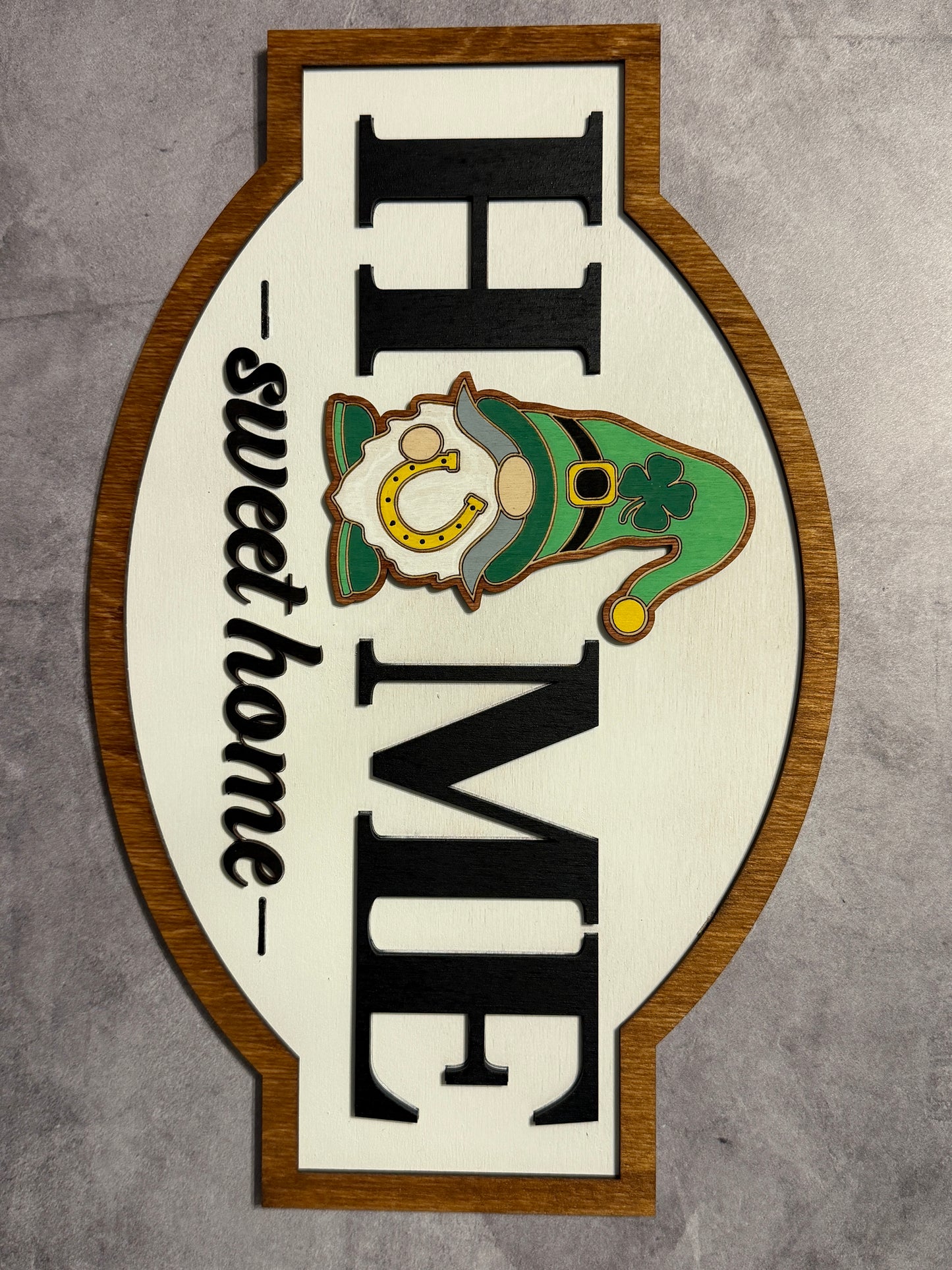Decorative sign with 'Home Sweet Home' and leprechaun design on a gray background
