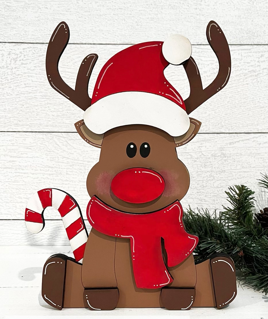 a wooden reindeer with a red nose and a red scarf and a candy cane