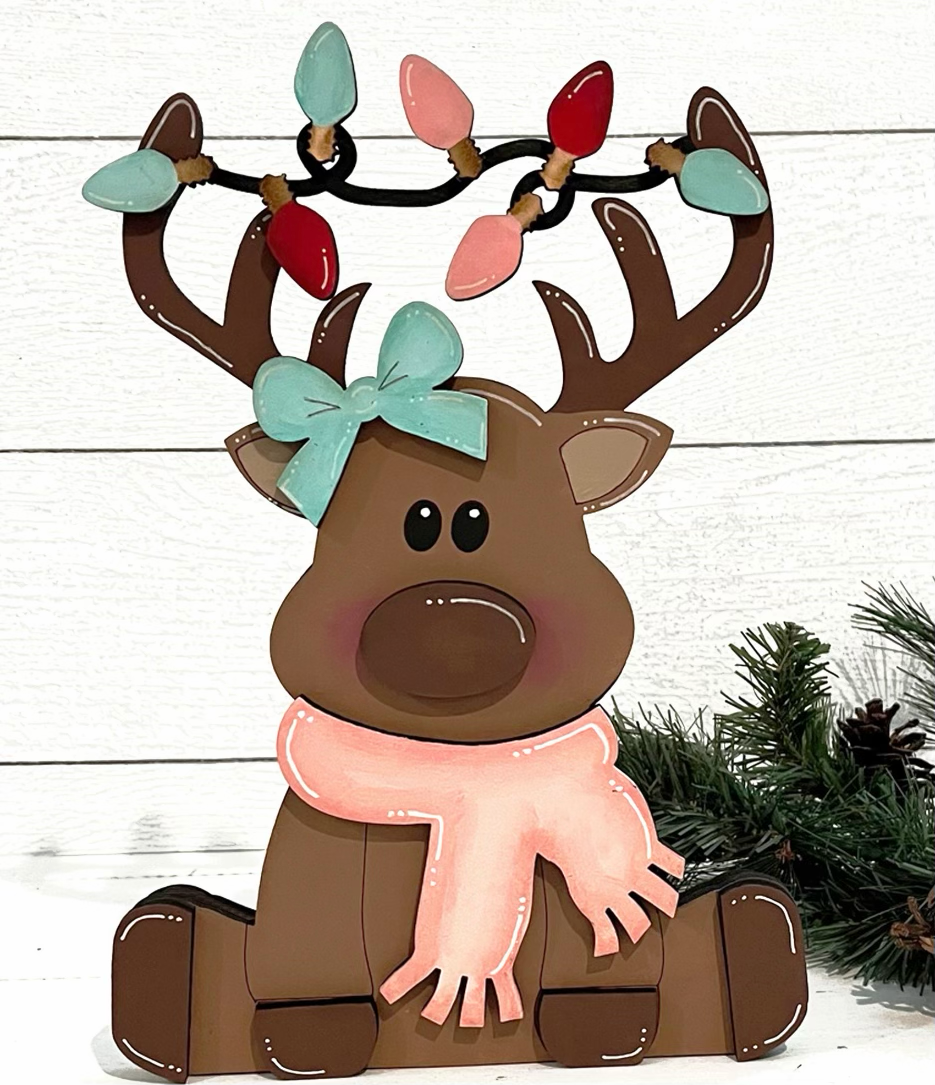 a wooden reindeer with a scarf and lights