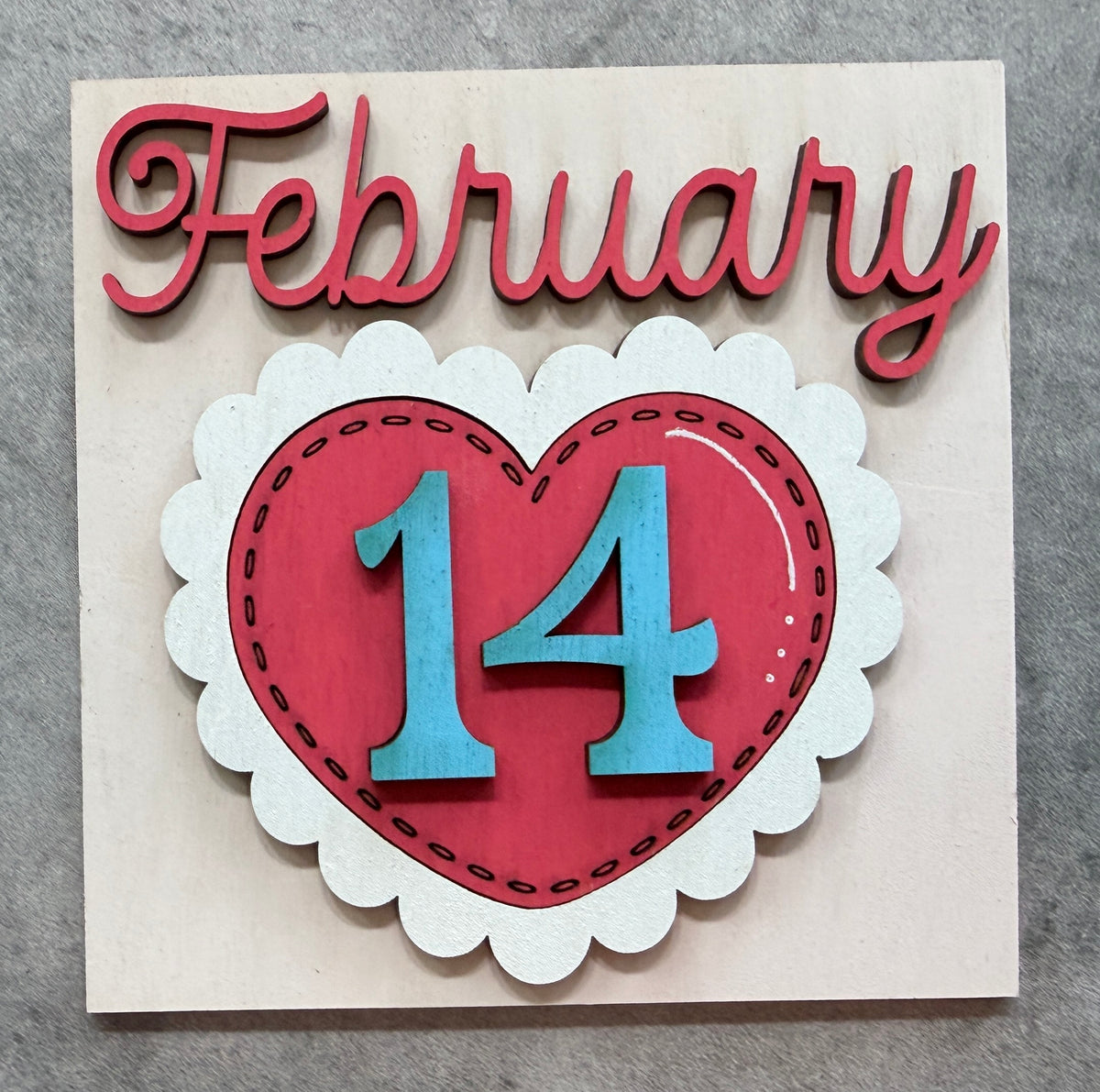 a wooden sign with a heart and date