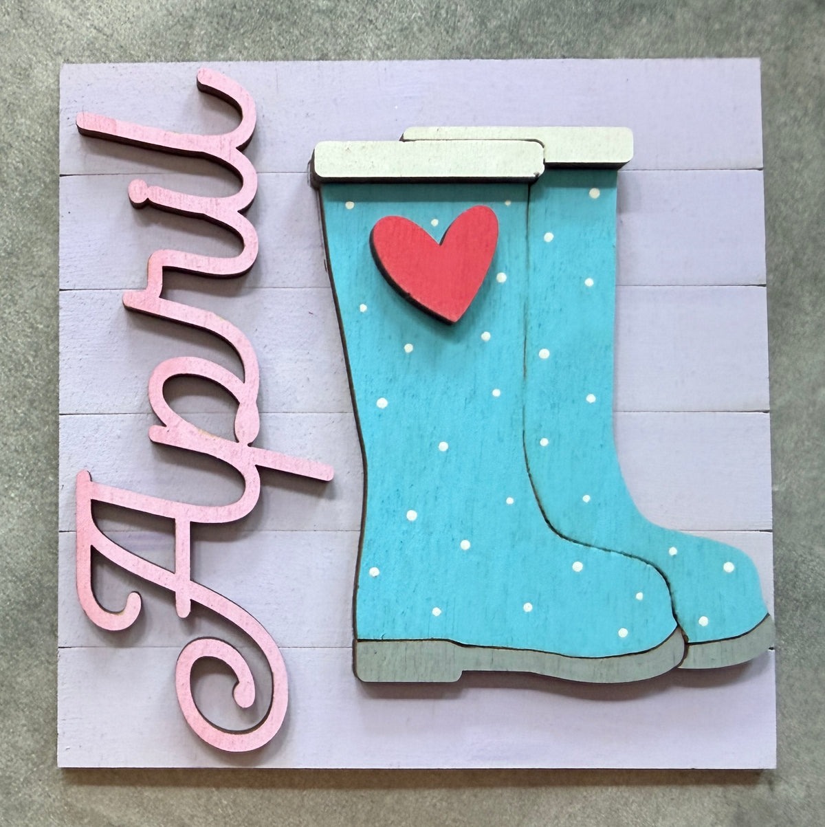 a wooden sign with a picture of boots and a heart