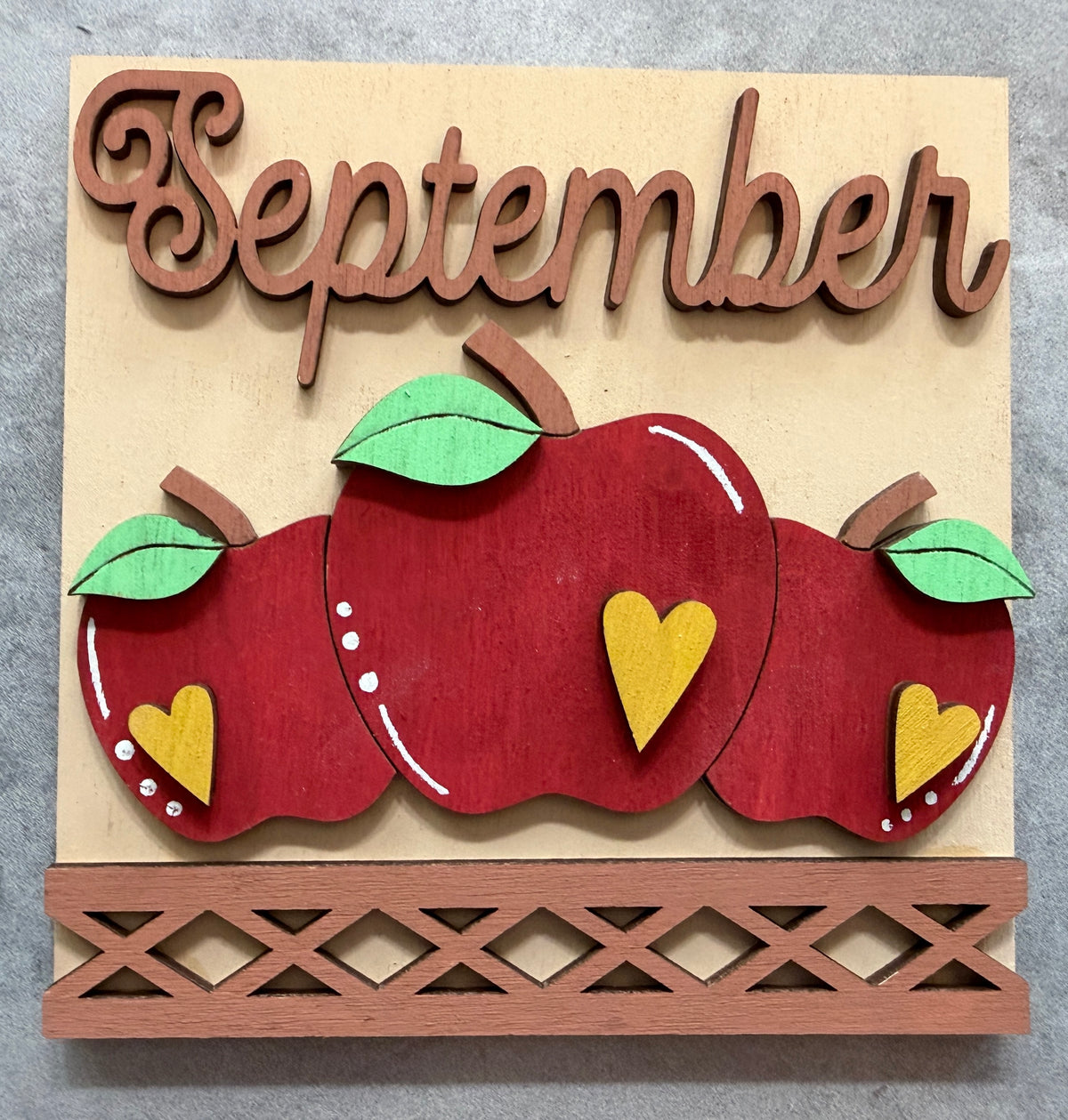 a wooden plaque with apples and words