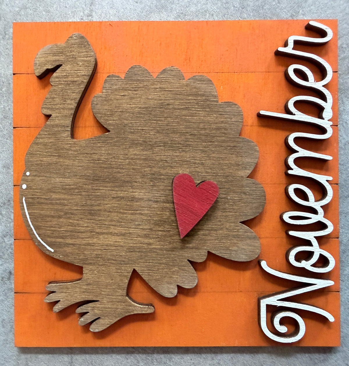 a wooden sign with a turkey and a heart