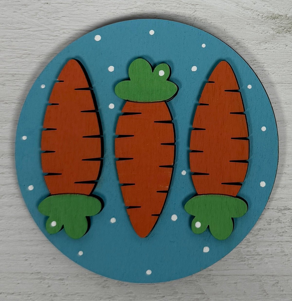a round wooden coaster with carrots on it