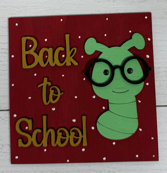 a sign with a worm wearing glasses