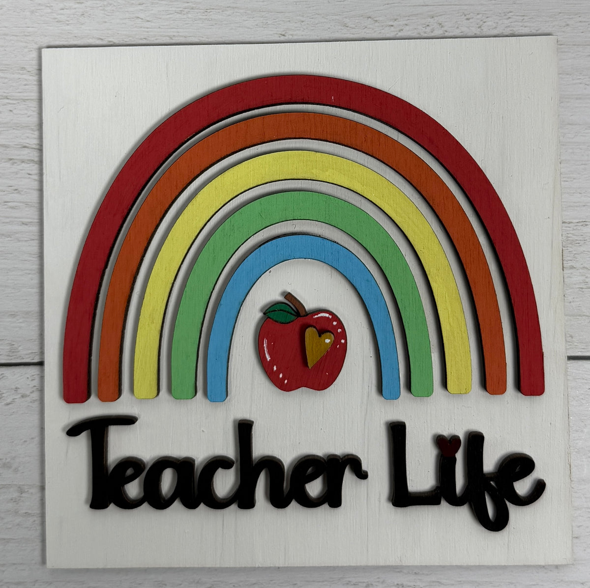 a rainbow and apple on a white surface