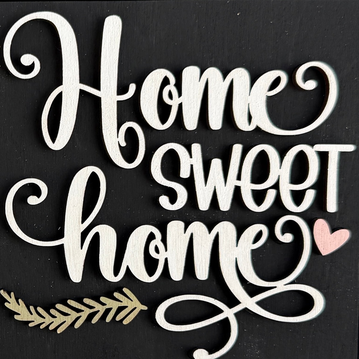 a white sign with a pink heart and a leaf