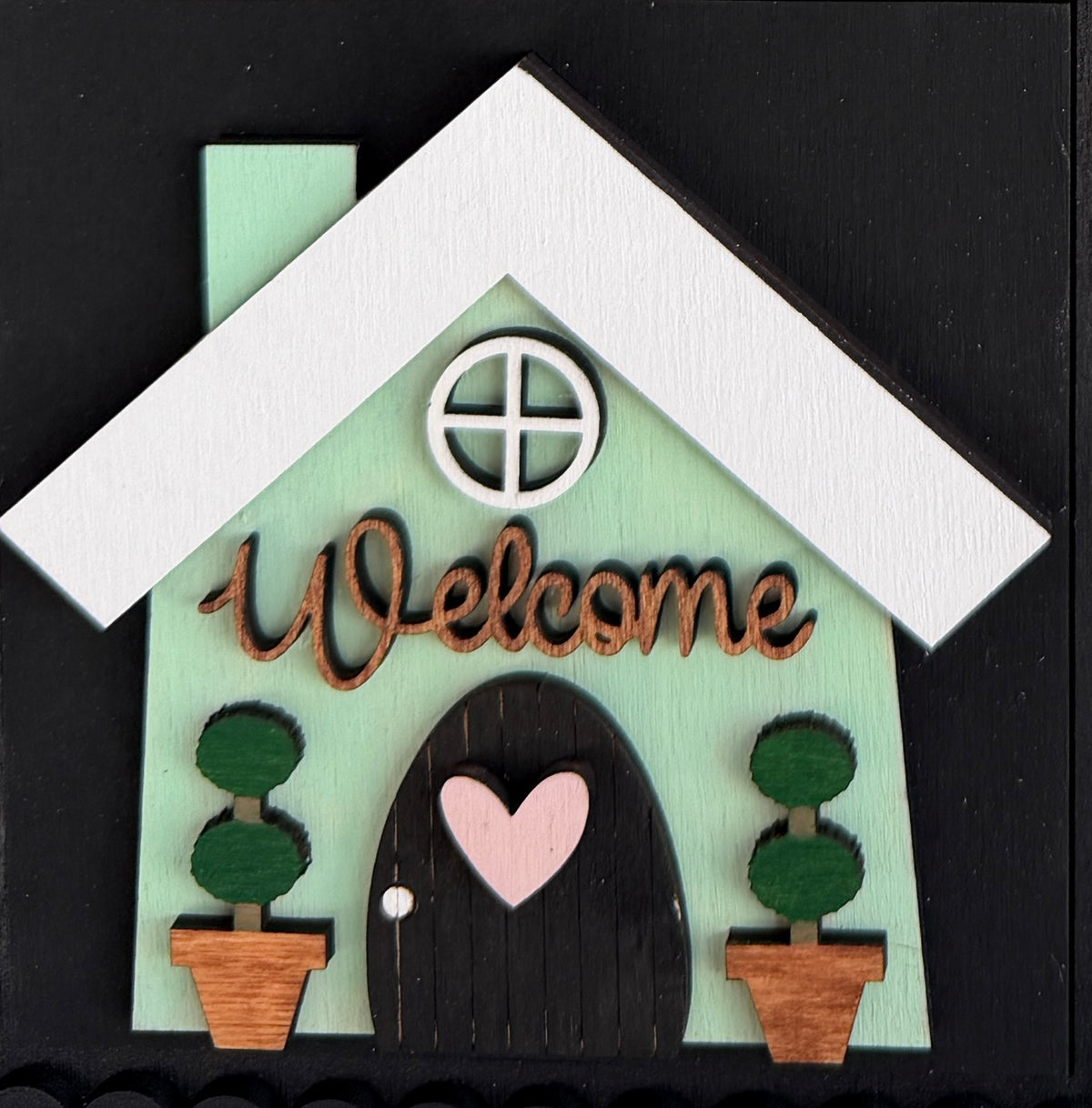 a sign with a house and potted plants