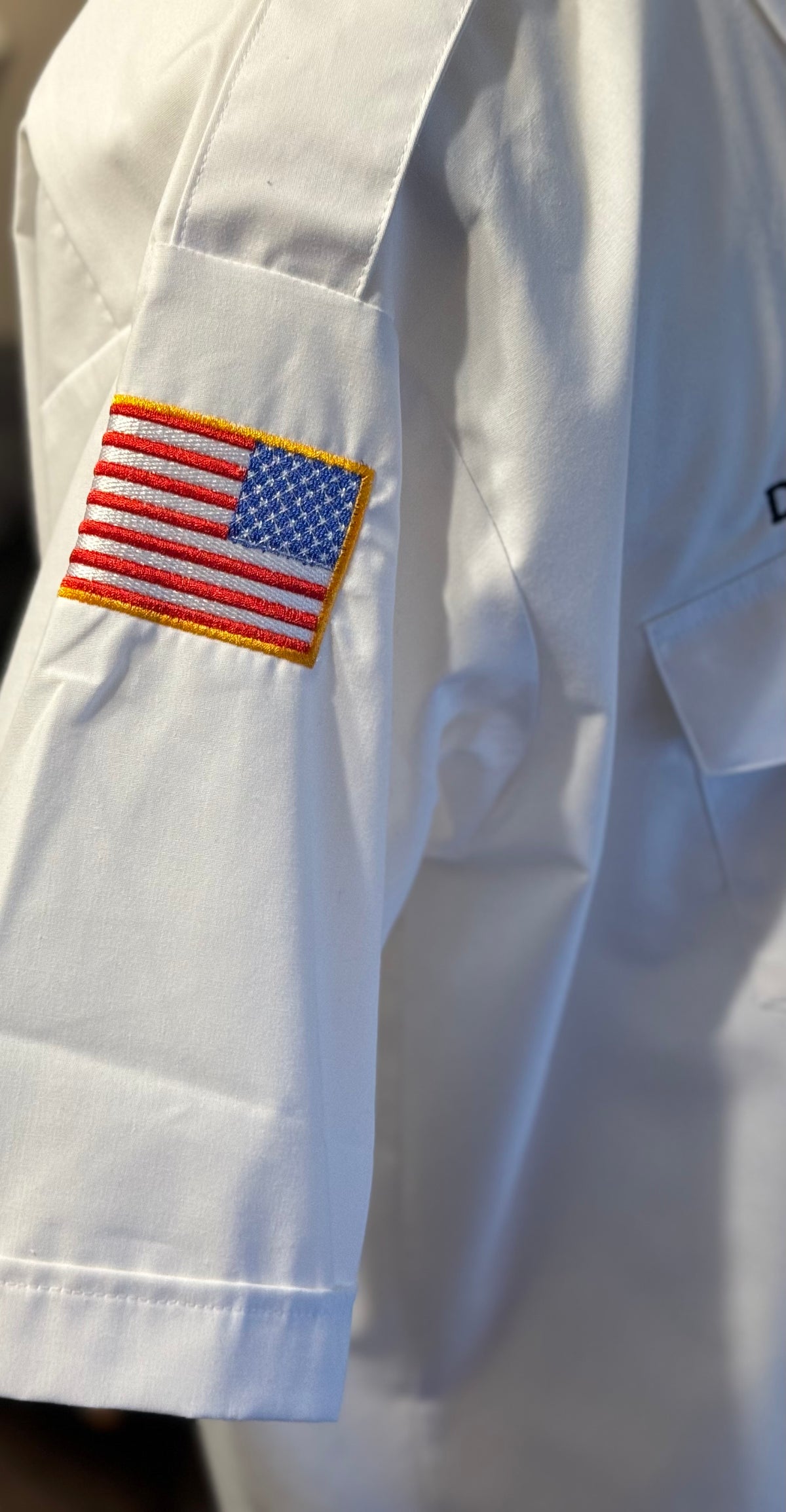 a flag patch on a sleeve of a white shirt