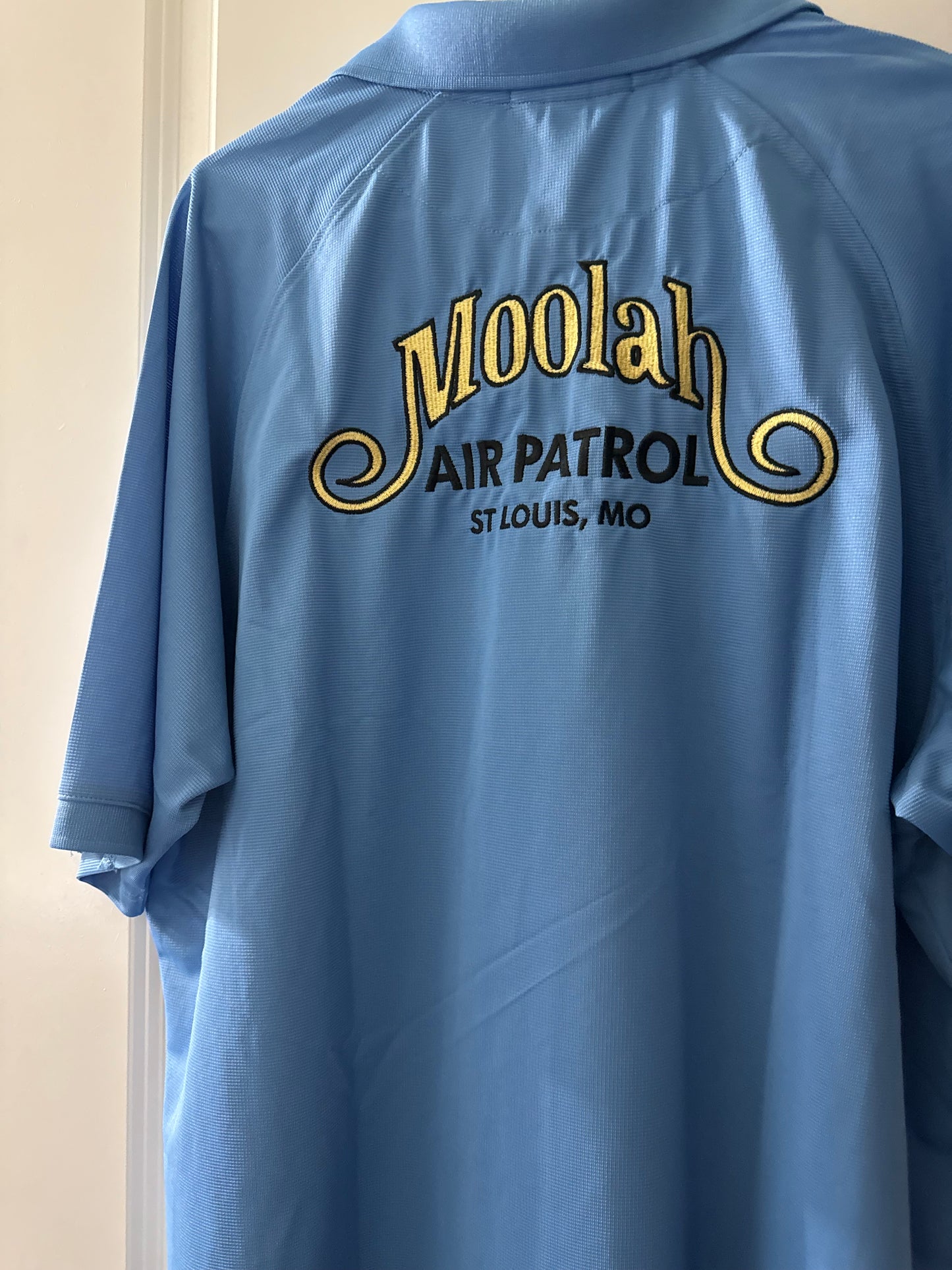 a blue shirt with yellow writing on it